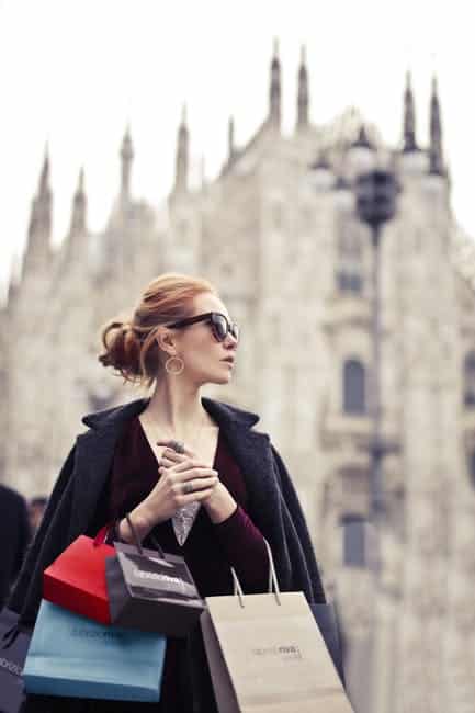 Shallow Focus Photography of Woman Holding Assorted-color Paper Bags